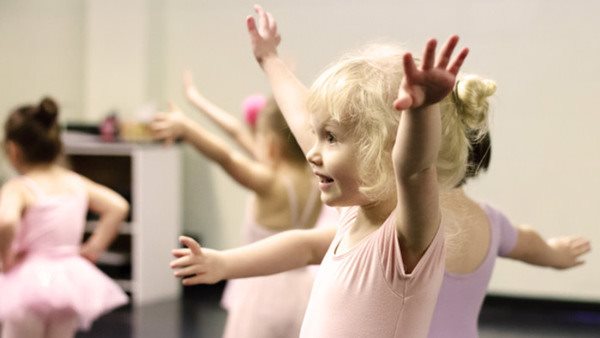 A toddler ballerina, happily focusing on her craft.