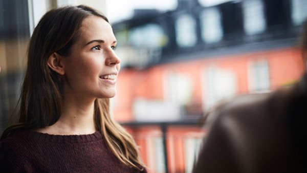 Kvinna som tittar ut genom ett fönster