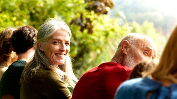 Portrait of smiling senior woman sitting with family at park