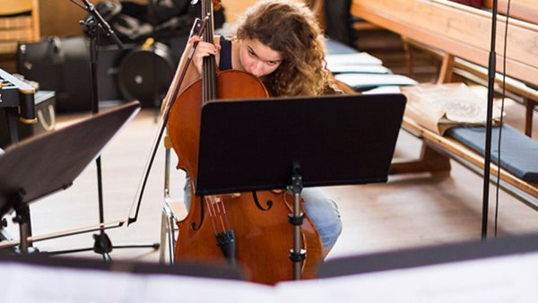 Kvinnlig cellist studerar noter på Gotlands Tonsättarskola