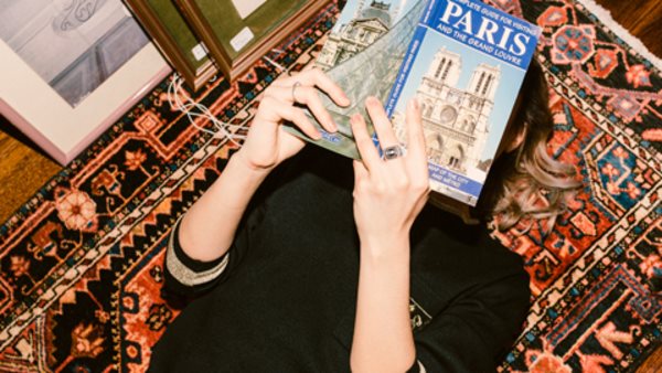 Kvinna läser guidebok om Paris. 