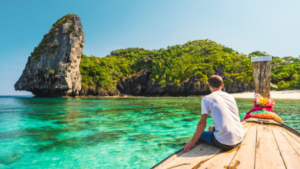 Deltagare njuter på en traditionell tråbåt i turkost hav - efter kurs i thailändska