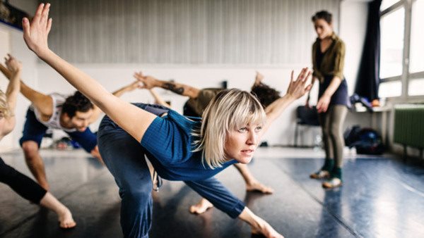 A group of young Dancers in a dancing studio performing during rehearsal