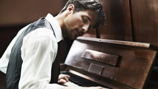 Attractive young pianist playing the piano with passion
