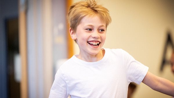 Pojke som skrattar på en kurs i jazz på Balettakademien Stockholm