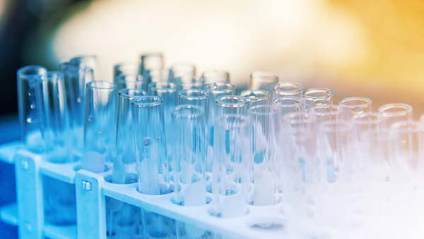 Lab science research glass items adding drop to one of several test tubes. A scientific experiment in a science research Laboratory.