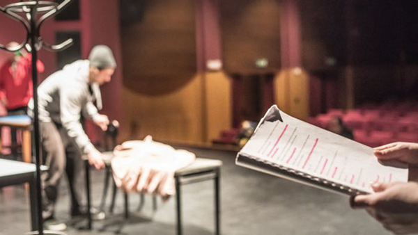 Tre deltagare förbereder en scen på produktionskurs i teater